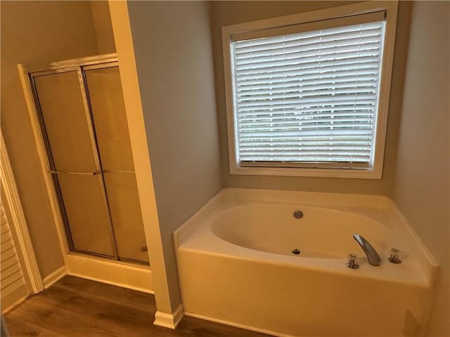 bathroom featuring wood-type flooring and separate shower and tub