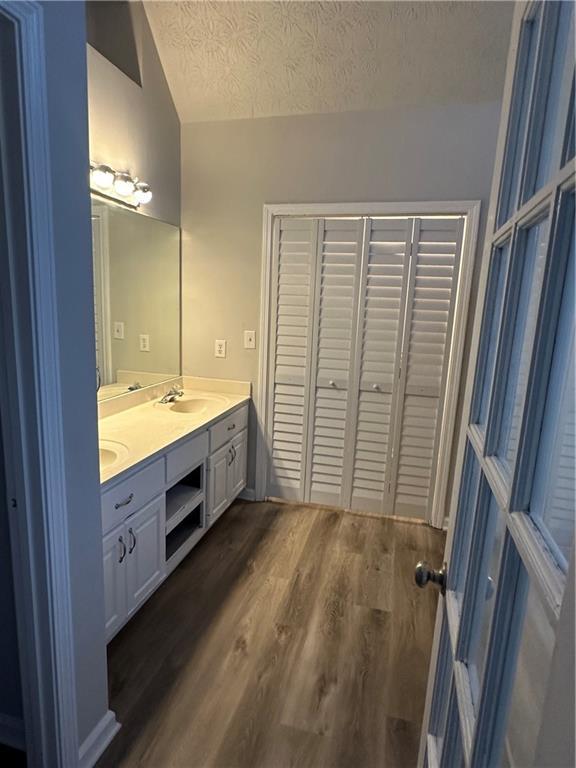 bathroom with vanity, hardwood / wood-style floors, and a textured ceiling