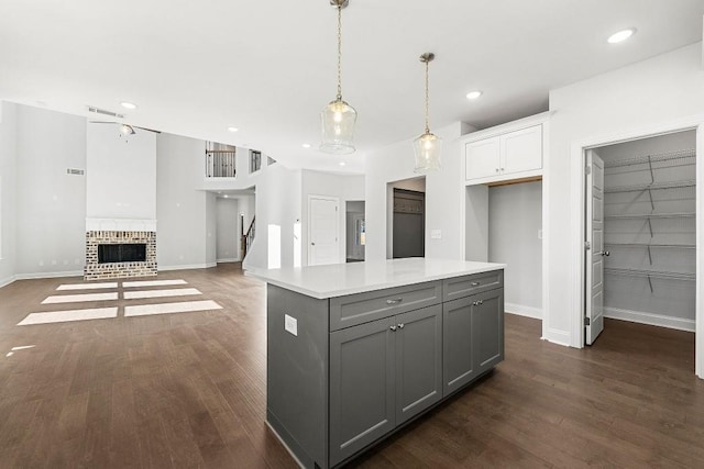 kitchen featuring a center island, light countertops, gray cabinetry, open floor plan, and white cabinets