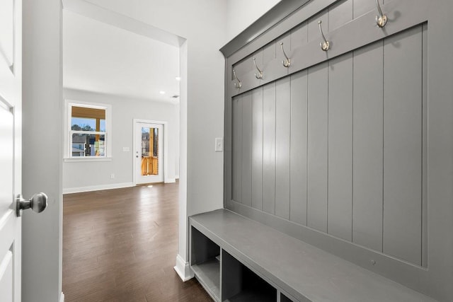 mudroom with baseboards and dark wood-type flooring