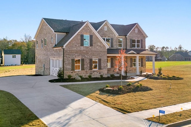 view of front of property featuring driveway, brick siding, stone siding, and a front yard