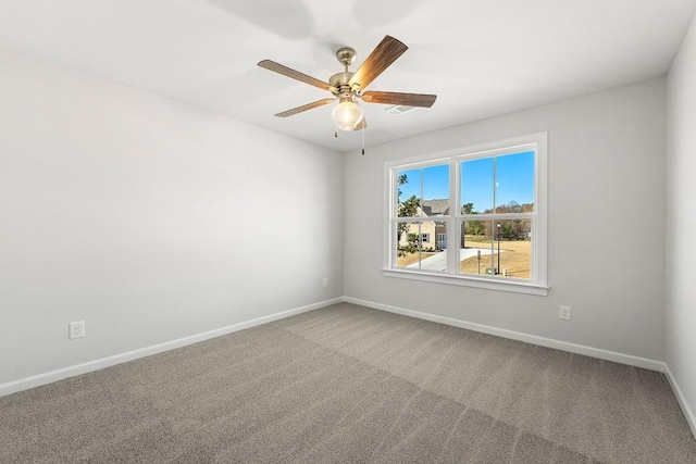 carpeted empty room featuring a ceiling fan and baseboards