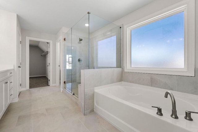 full bathroom featuring lofted ceiling, a garden tub, vanity, baseboards, and a shower stall