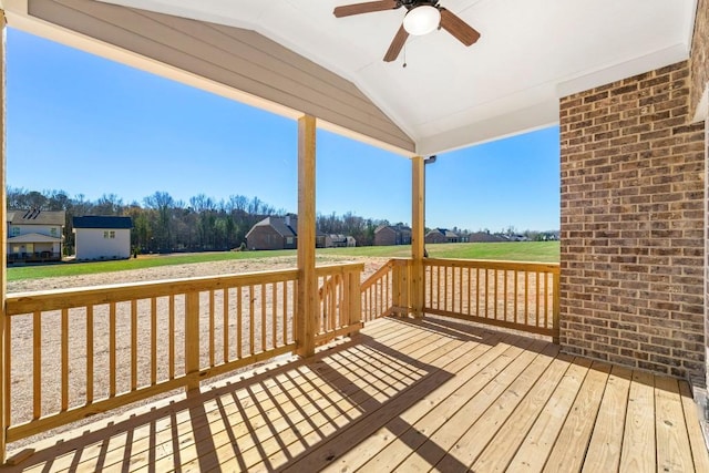 deck featuring a ceiling fan and a lawn