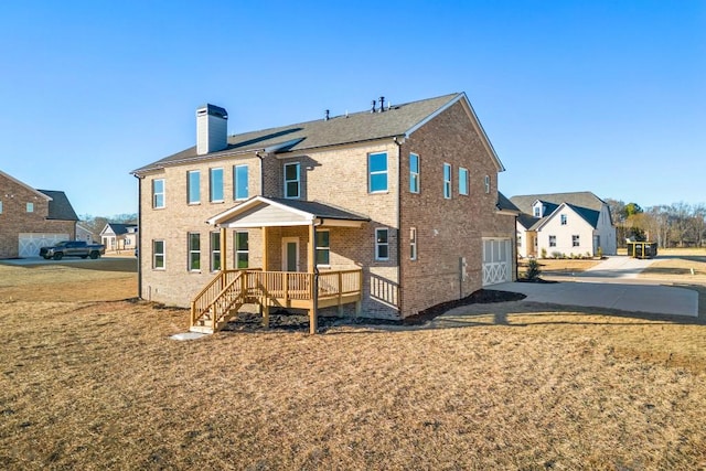 back of property featuring a yard, brick siding, a chimney, and a residential view