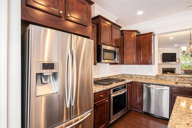 kitchen with crown molding, light stone counters, dark hardwood / wood-style flooring, stainless steel appliances, and a chandelier