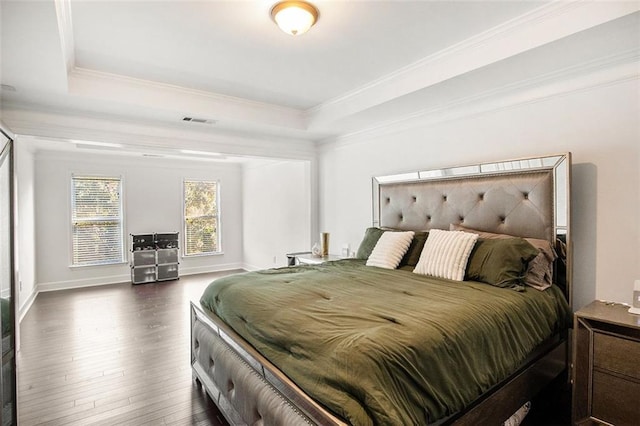 bedroom featuring dark hardwood / wood-style floors, a raised ceiling, and crown molding