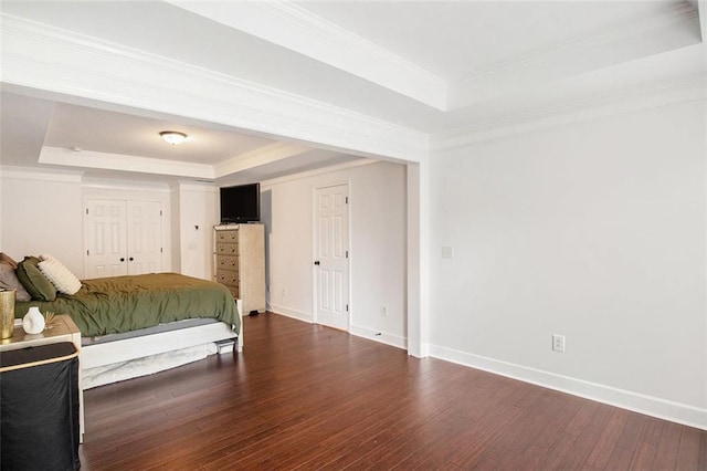 bedroom with dark hardwood / wood-style flooring, a raised ceiling, and crown molding