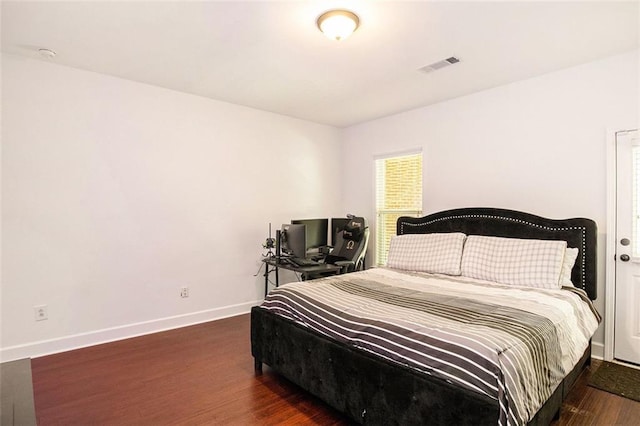 bedroom with dark hardwood / wood-style floors