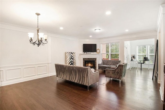 living room with a chandelier, dark hardwood / wood-style flooring, and crown molding