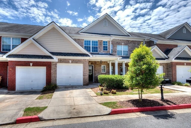 view of front of home featuring a garage, driveway, and brick siding