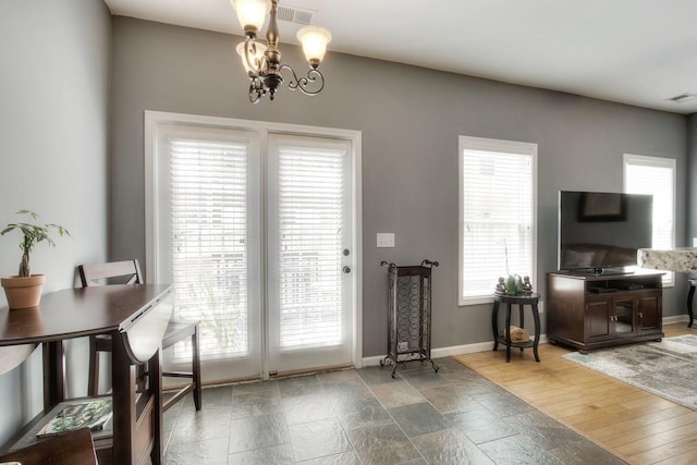 doorway with hardwood / wood-style flooring, a wealth of natural light, and a chandelier