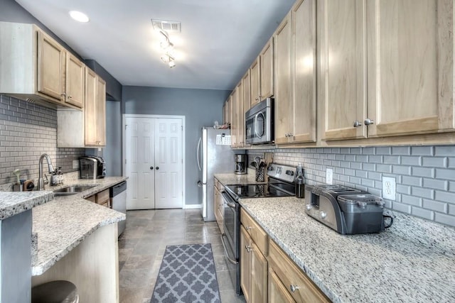 kitchen featuring light brown cabinetry, light stone counters, stainless steel appliances, sink, and decorative backsplash