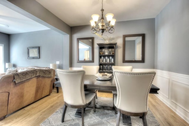 dining space featuring light hardwood / wood-style flooring and a notable chandelier