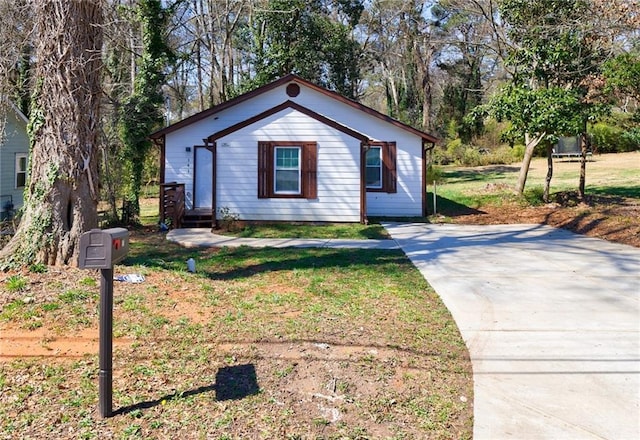 141 Nathan Rd, Atlanta, GA 30331 - bungalow-style house with concrete driveway, a front yard, and view of wooded area
