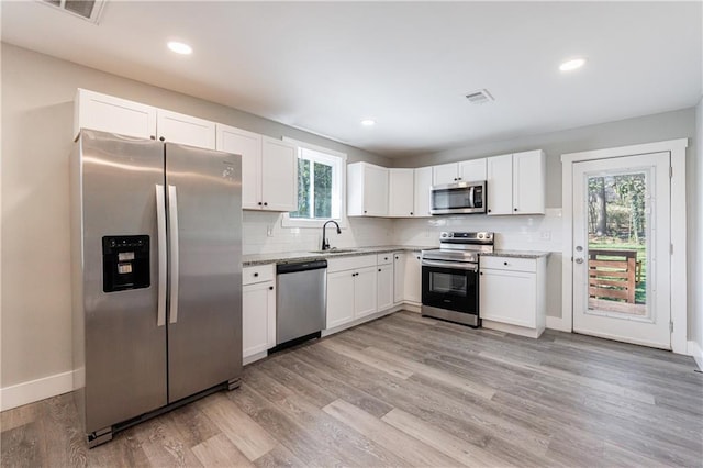 141 Nathan Rd, Atlanta, GA 30331 - kitchen featuring stainless steel appliances, a sink, white cabinetry, baseboards, and light wood-style flooring