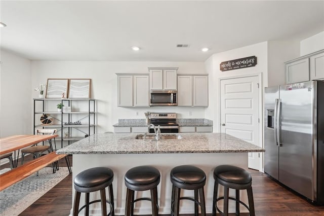 29 Gaston Ct, Hoschton, GA 30548 - kitchen featuring appliances with stainless steel finishes, gray cabinetry, a sink, dark wood-style flooring, and light stone counters