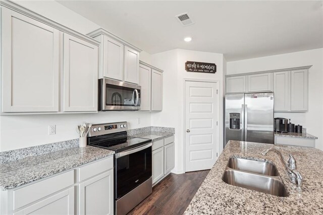 29 Gaston Ct, Hoschton, GA 30548 - kitchen with appliances with stainless steel finishes, a sink, dark wood finished floors, light stone countertops, and recessed lighting