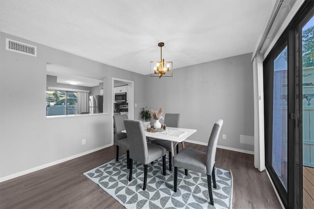 dining space featuring a notable chandelier and dark hardwood / wood-style floors