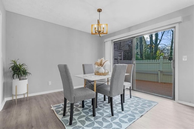 dining space with hardwood / wood-style flooring and a chandelier