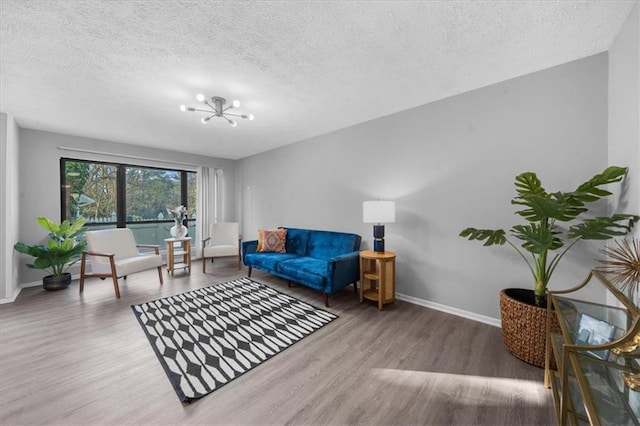 living room featuring hardwood / wood-style flooring, a chandelier, and a textured ceiling