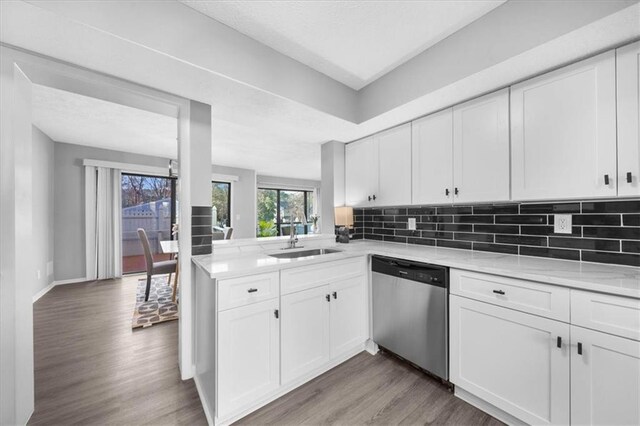 kitchen featuring stainless steel appliances, white cabinetry, backsplash, and light wood-type flooring