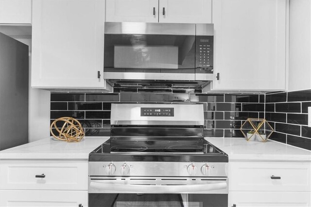 kitchen featuring sink, dishwashing machine, white cabinets, backsplash, and light stone countertops