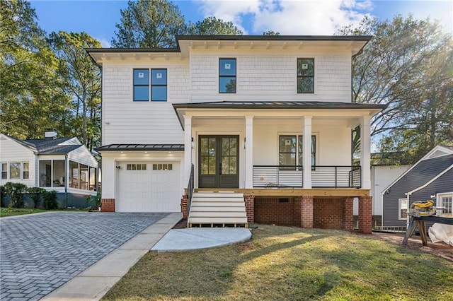 view of front of property featuring a front yard, a porch, a garage, and french doors