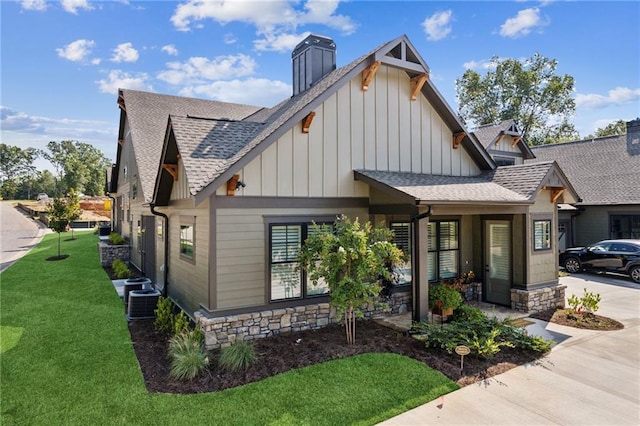 view of front of home with a front lawn and central AC