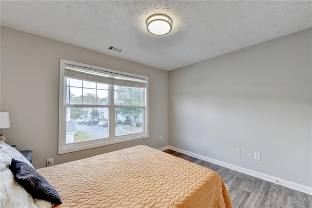 bedroom featuring a textured ceiling and hardwood / wood-style floors