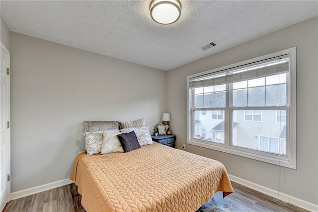 bedroom featuring wood-type flooring and a textured ceiling