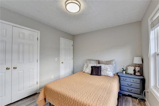 bedroom featuring a textured ceiling, a closet, and hardwood / wood-style floors