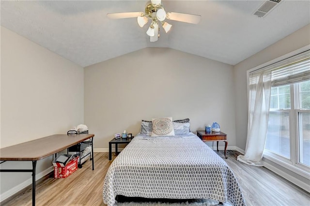 bedroom with light hardwood / wood-style floors, lofted ceiling, and ceiling fan