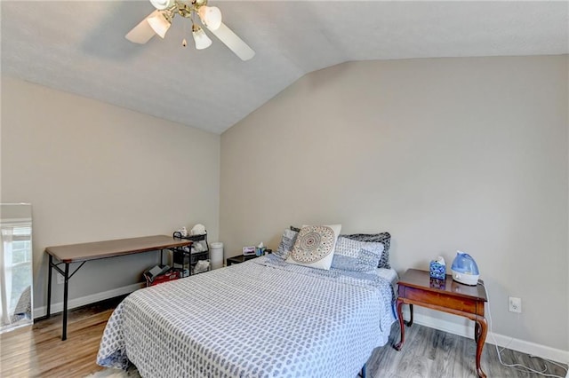 bedroom with ceiling fan, lofted ceiling, and hardwood / wood-style floors