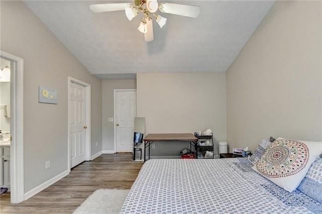 bedroom featuring ceiling fan, connected bathroom, and hardwood / wood-style floors