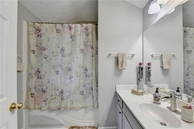 bathroom with a textured ceiling, vanity, and shower / bathtub combination with curtain