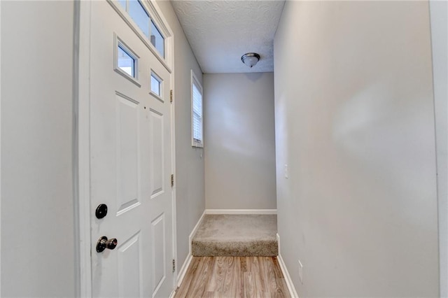 entryway with a textured ceiling and light hardwood / wood-style floors