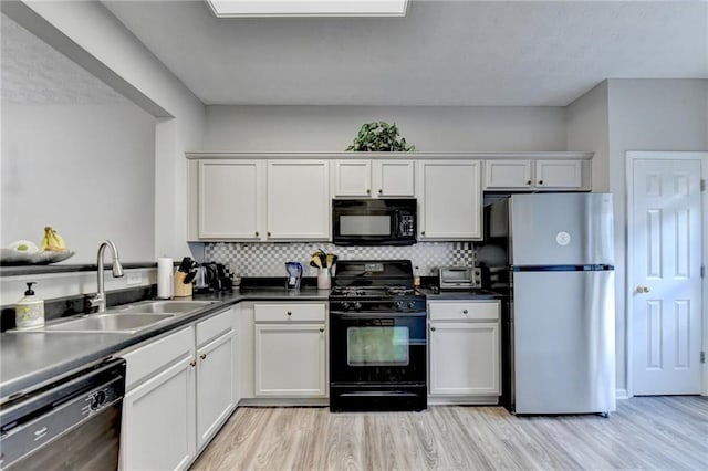 kitchen featuring black appliances, white cabinetry, and sink