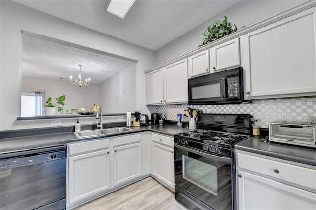 kitchen with light wood-type flooring, tasteful backsplash, sink, a notable chandelier, and black appliances