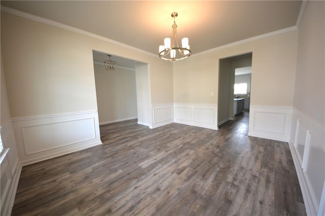 7753 Hansel Ln, Lithonia, GA 30058 - unfurnished dining area with a chandelier, dark wood-style flooring, a wainscoted wall, a decorative wall, and ornamental molding