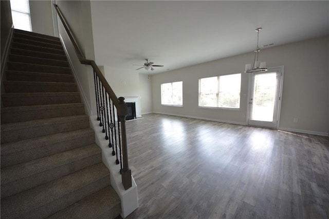 7753 Hansel Ln, Lithonia, GA 30058 - unfurnished living room featuring a ceiling fan, wood finished floors, stairway, and a fireplace