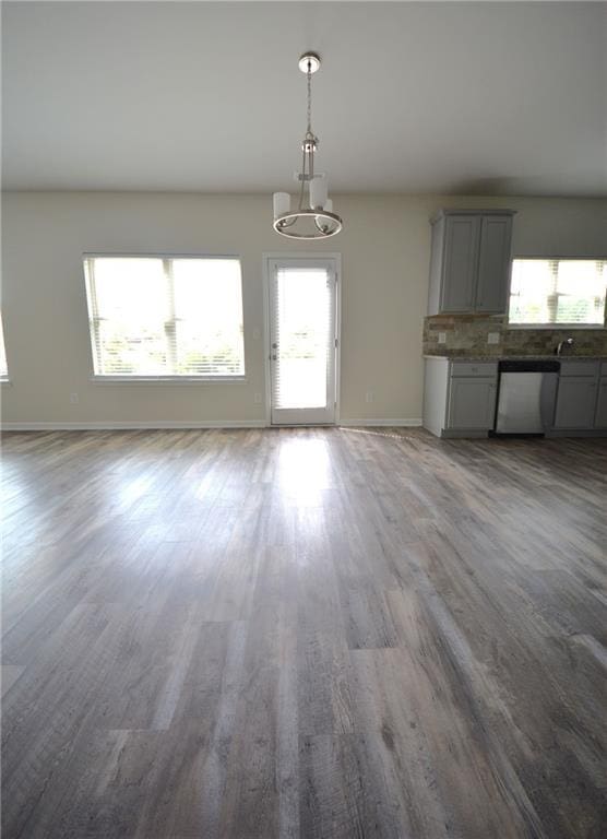 7753 Hansel Ln, Lithonia, GA 30058 - unfurnished living room with healthy amount of natural light, wood finished floors, and a chandelier