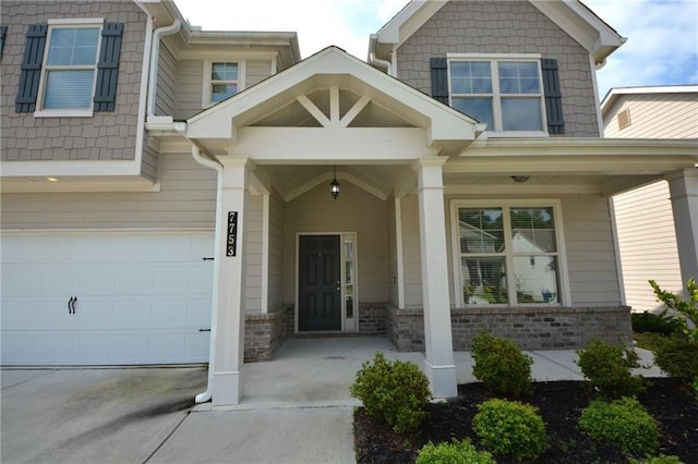 7753 Hansel Ln, Lithonia, GA 30058 - entrance to property with driveway, a porch, an attached garage, and brick siding