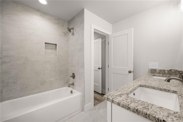 bathroom with vanity and tiled shower / bath