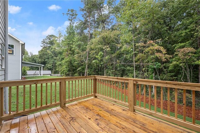 wooden terrace featuring a lawn