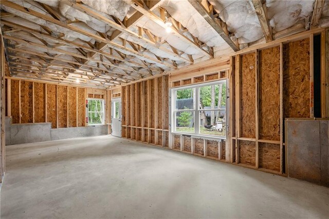 misc room with a healthy amount of sunlight and concrete flooring