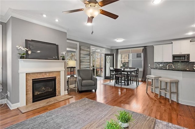 1604 Gilstrap Ln NW, Atlanta, GA 30318 - living room featuring ornamental molding, a fireplace, wood finished floors, recessed lighting, and ceiling fan