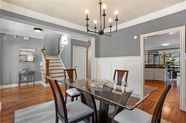 1604 Gilstrap Ln NW, Atlanta, GA 30318 - dining room featuring a chandelier, wood finished floors, crown molding, and stairs