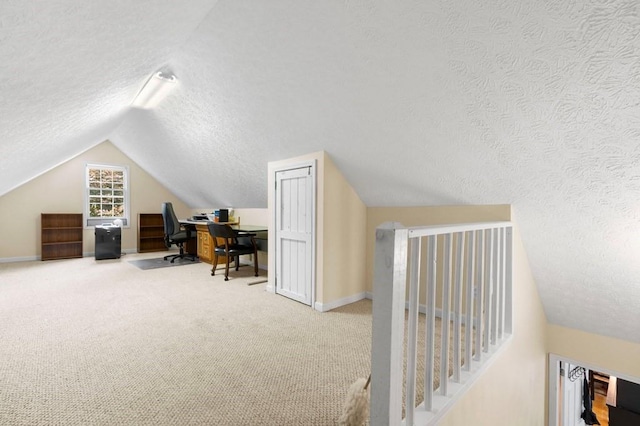 office area with a textured ceiling, vaulted ceiling, and carpet floors