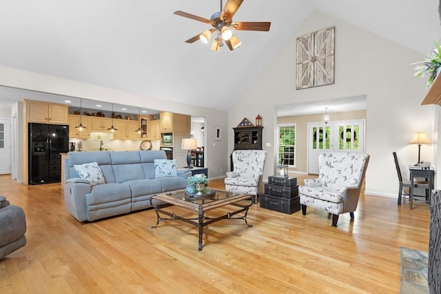 living room featuring high vaulted ceiling, ceiling fan, and light hardwood / wood-style flooring